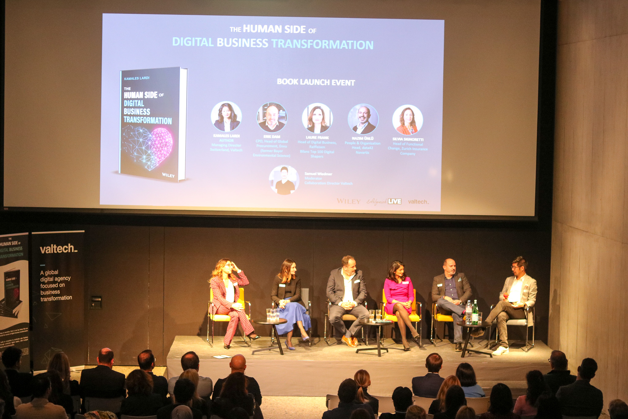 Panel on stage below the slide for The Human Side of Digital Business Transformation